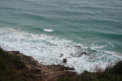 海浪撞在褐色的岩石海岸白天
